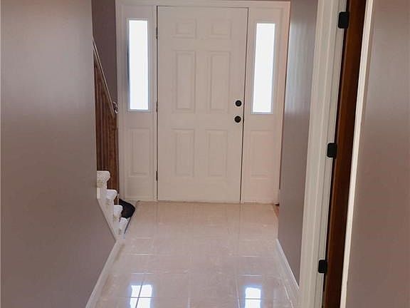 Nice clean, wide entry hall with ceramic tile.