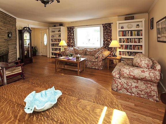 Spacious living room has hardwood floors and wood burning fireplace