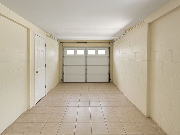 Garage has a door from the living room into the garage. Tiled floors and AC Vent for additional living space.
