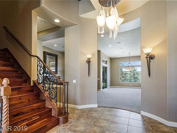 Entry with custom chandelier and stairs will real wood