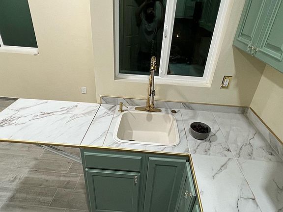 Smartly arranged kitchen space featuring a white single-basin sink and a drop-down counter_ideal for food prep or casual meals without compromising space.