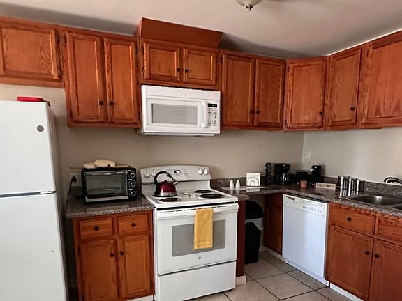 This spacious, modern kitchen features sleek countertops, ample cabinet storage.