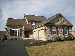 Front Elevation featuring stacked stone and oversized side-load 2-car garage