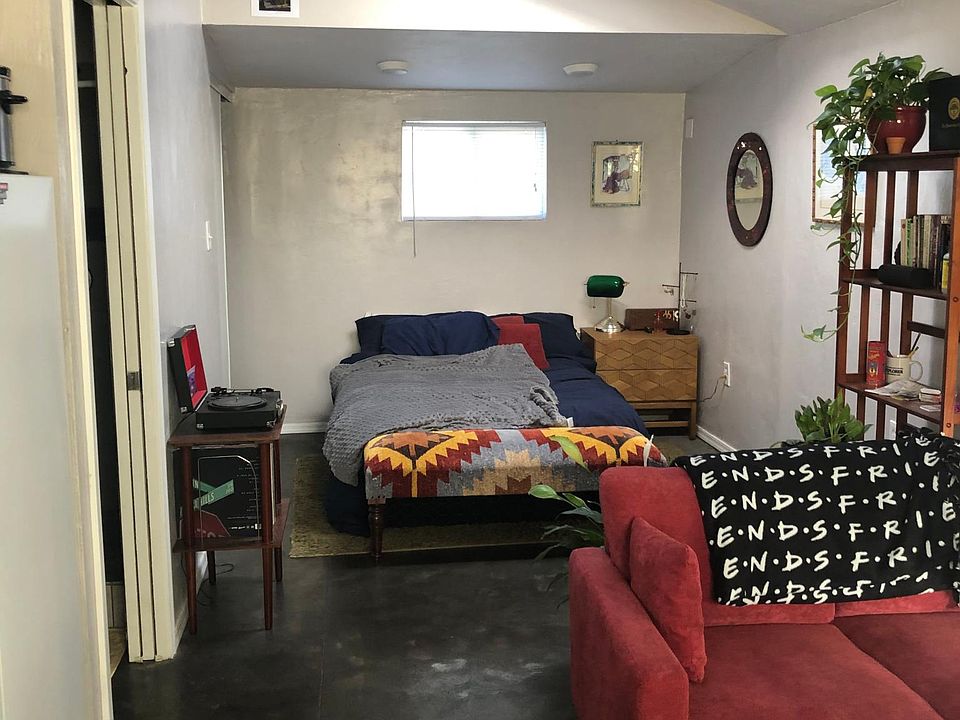 Studio living area with stained concrete floors. Wood beam can be used to drape off sleeping area from living area.