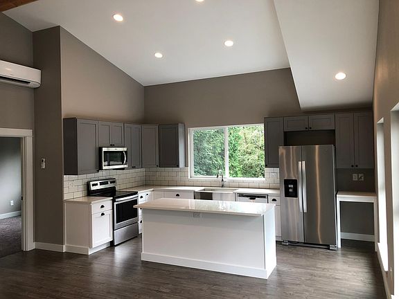Kitchen with large island, SS appliances, shaker cabinets, farm sink, quartz countertops, and 6ft x 4ft window for lots of natural light.