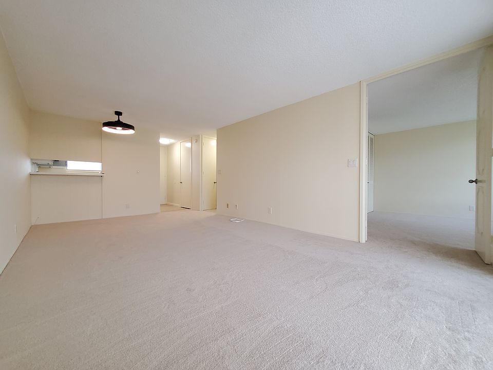 Spacious living and dining room with fresh paint, new carpeting, and fandelier