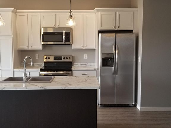 Kitchen with island counter and stainless steel appliances with ice maker.