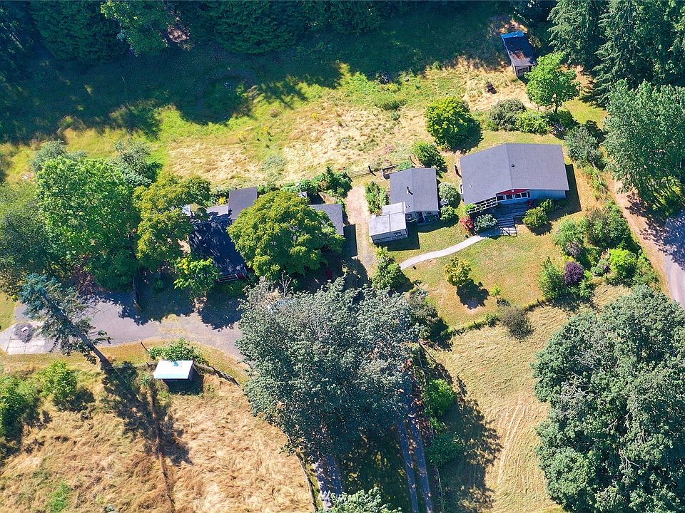Aerial view of the 3 structures: At right is the 1 bedroom home that originally was a Montessori School, to Its left is a studio unit that originally was the Owner's "guest house". In the center of the photo is what was once a barn that now is the owner's residence:  Entry, Kitchen/Dining area (w/antique woodburning range), main floor 3/4 bathroom and stairs to Loft/Living room, bedroom and ensuite 3/4 bath.  At the left end of the "Barn" is another guest house and behind the unit is a tandem 2-car garage & shop with 3 storage units and a laundry room with washer & dryer.>