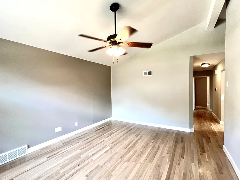 Living room with feature wall, looking into hallway.