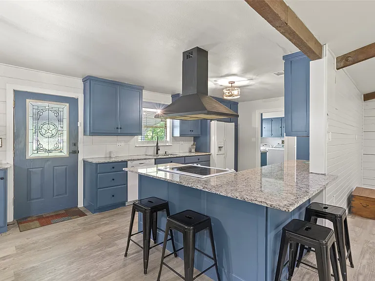 Kitchen featuring blue cabinetry, light granite countertops, and a built-in electric cooktop with a range hood