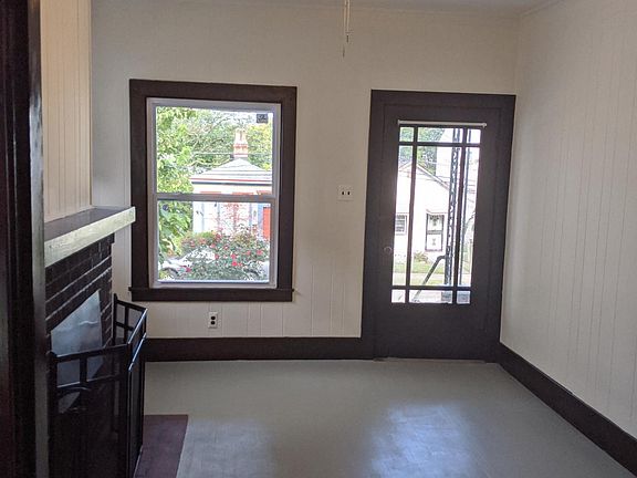 Living room/bonus room #1 with a real wood-burning fireplace (!) and access to the covered front porch and William St.