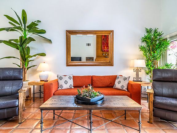 Warm and inviting living space featuring Saltillo tile floors, fireplace, comfortable seating, and curated desert-inspired decor. Bright, airy layout designed for relaxed evenings and effortless entertaining in Santa Rosa Cove.