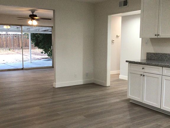From kitchen to great room with large sliding door to covered concrete patio and large unfinished backyard. Ceiling fans and contemporary downlights are located throughout the home. Showing again, a large expanse of the beautiful new laminate flooring wi