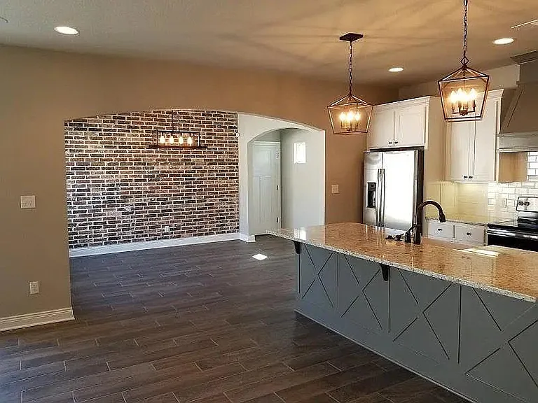 kitchen to the right of picture with the dining room with the brick wall in the background
