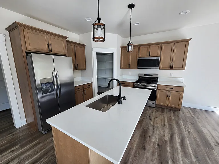 Beautiful kitchen with quartz countertop and all new appliances (gas stove and strong fan on microwave that vents directly outside).