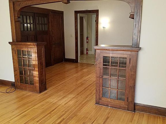 Looking toward DR and door to kitchen. Built-in display cases. Hardwood floors.