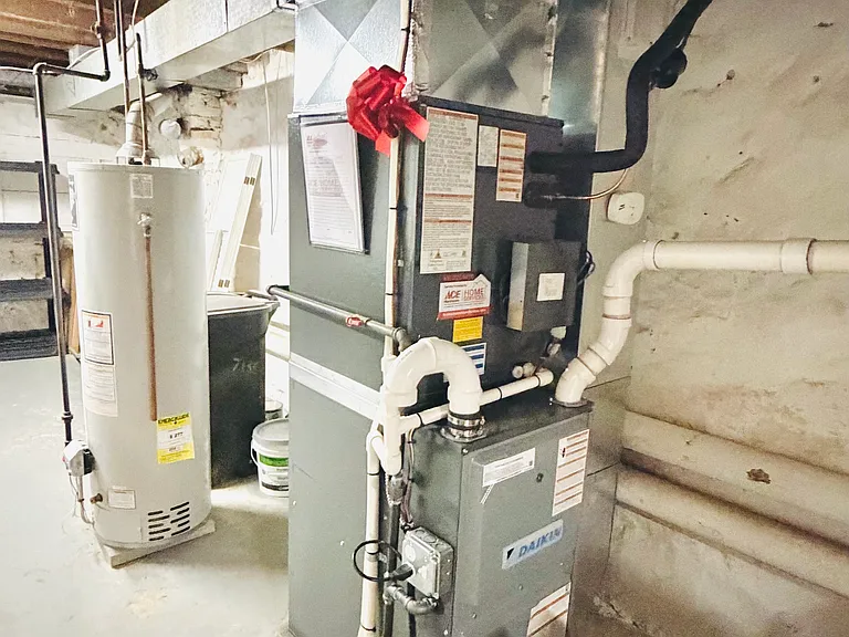 Daikin central air and heating unit with hot water heater in the basement _ modern climate control for year-round comfort.