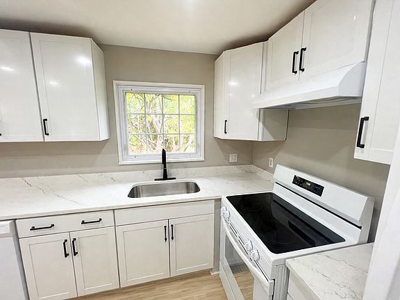 Designer Finish Kitchen 274 sq/ft with shaker cabinets, marble counters, white appliances, LVP flooring, pantry room, ample storage
