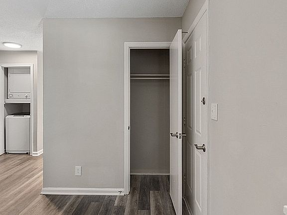 Explore this serene apartment corner featuring a spacious closet and sleek laundry area.