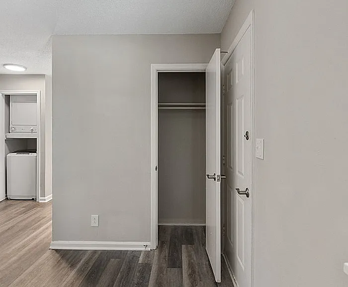 Explore this serene apartment corner featuring a spacious closet and sleek laundry area.