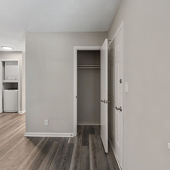 Explore this serene apartment corner featuring a spacious closet and sleek laundry area.