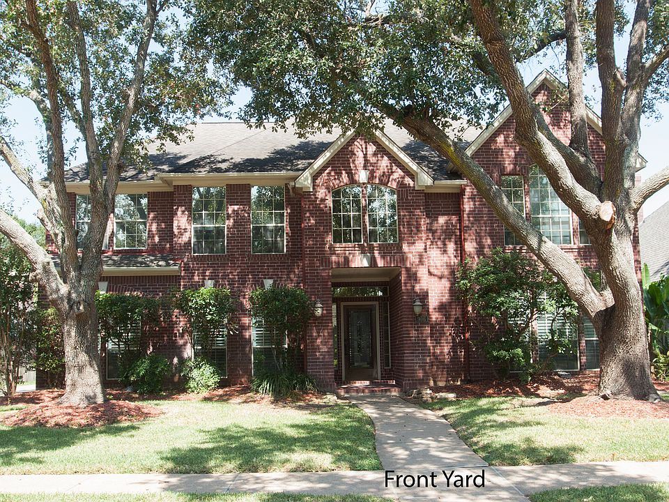 Front yard with mature live oak trees.