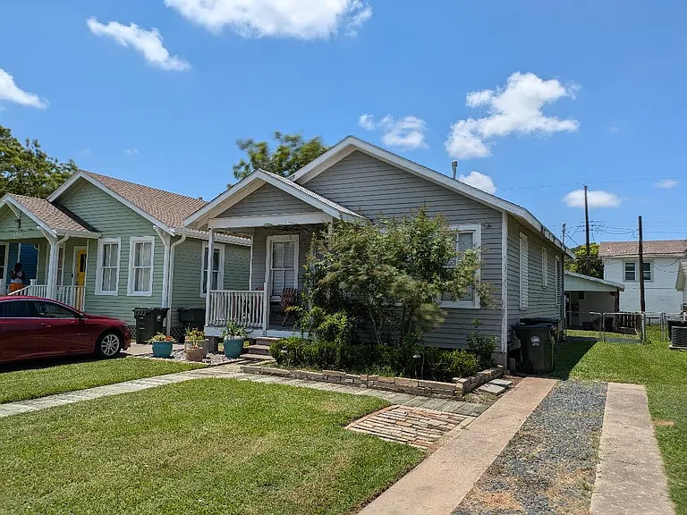 Driveway and side of house leading to fenced backyard.
