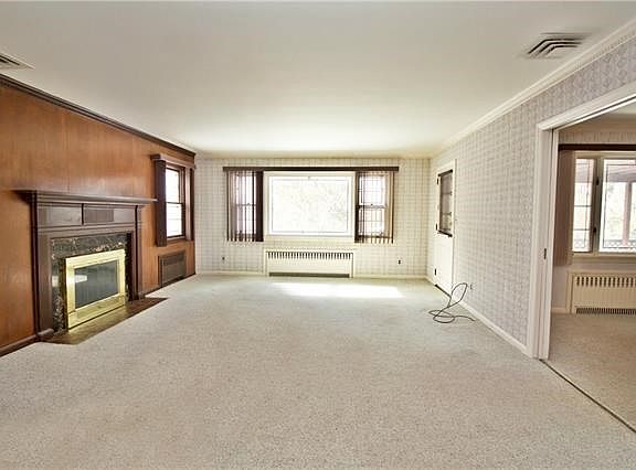 Sweeping view of the yard from living room.  Living room opens to formal dining room with pocket doors and accesses the covered porch.