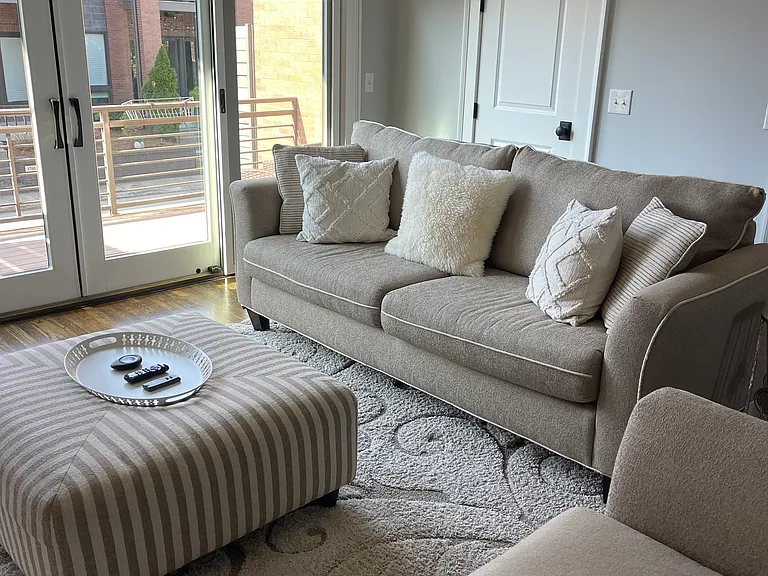 Living room with large balcony outside.