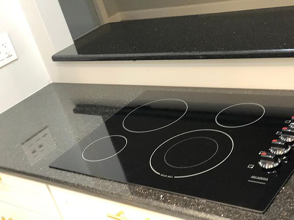 Custom built kitchen with flat top glass stove, Black Galaxy granite, built in-oven, all new appliances, cabinets and floor.