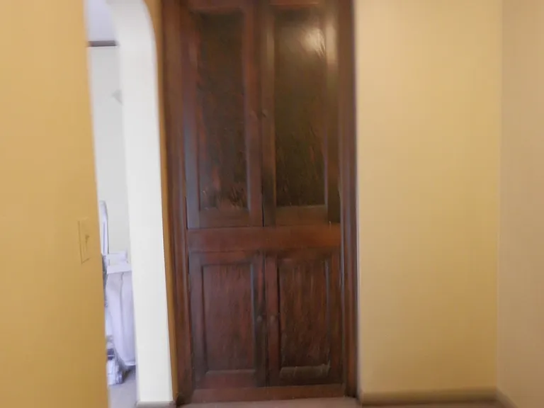 through archway in dining to small office nook/hallway with built ins. Leads to bedroom 2