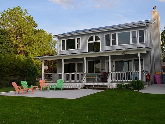 Covered rear deck of Main Home, windows galore and a cement patio to enjoy your lakefront view