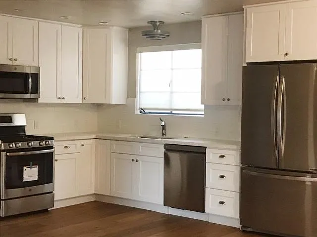 Open kitchen with stainless steel appliances. Soft-close drawers, quartz countertops.