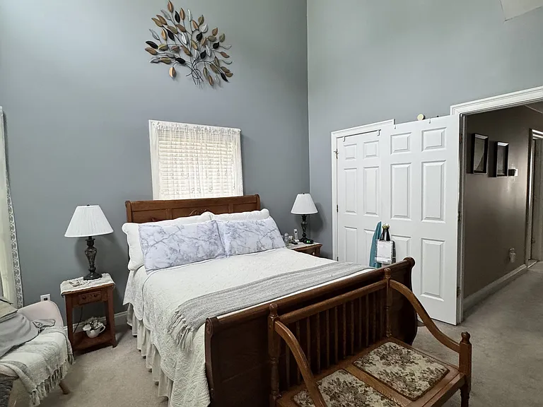 Primary bedroom with vaulted ceiling and a large fan.