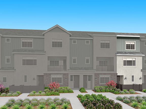 A multi-story residential building with a gray exterior, surrounded by landscaped gardens and a clea