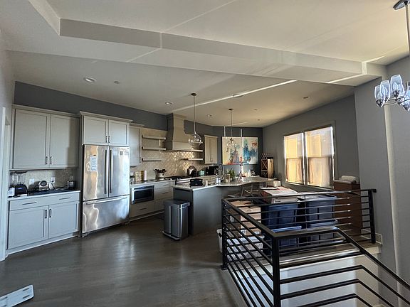 Kitchen has newly updated paint in shades of gray and blue hardwoods throughout