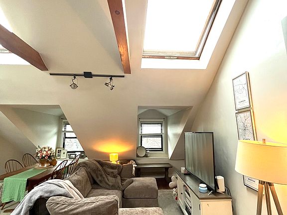 Living room area with vaulted ceilings and skylights