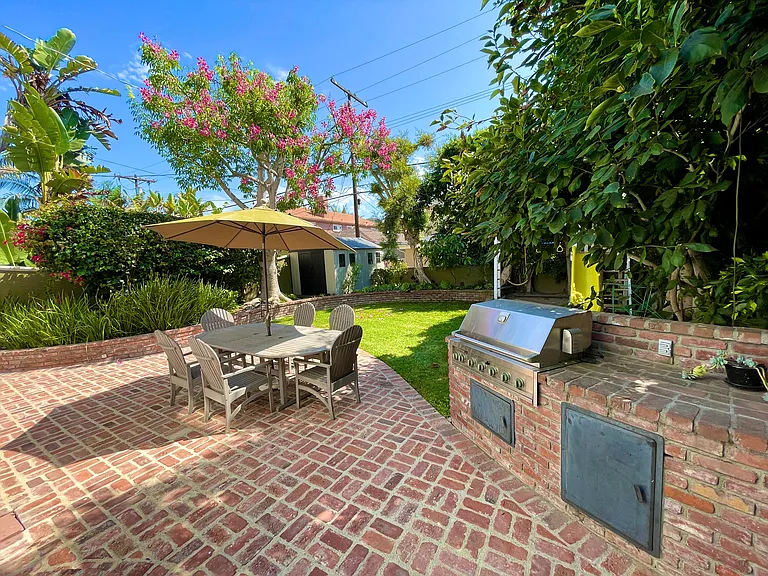 Entertain with ease at the built-in BBQ area, ideal for outdoor cooking and gatherings in this spacious lush backyard.