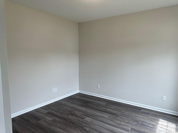 Spare room with baseboards and dark wood finished floors