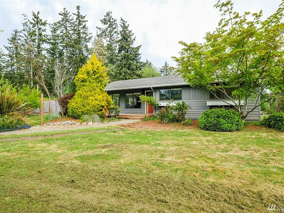 Sitting on the front of the property is one story home with mature landscape.