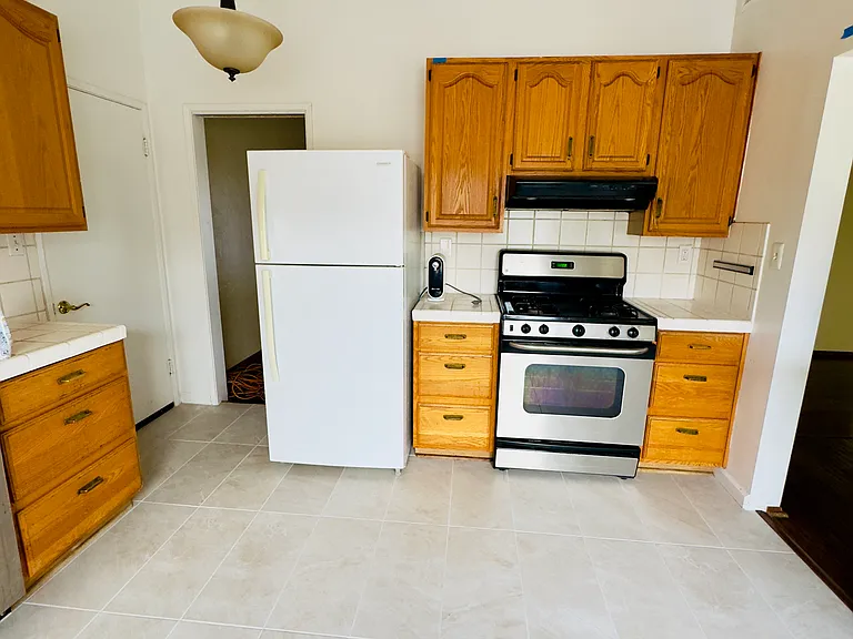 Kitchen area. Includes Oven, Gas Burning Stove Top, Dishwasher, Refrigerator, Microwave and Counter Top Bar.