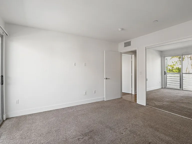 Bedroom with Mirrored Closet and Patio Access