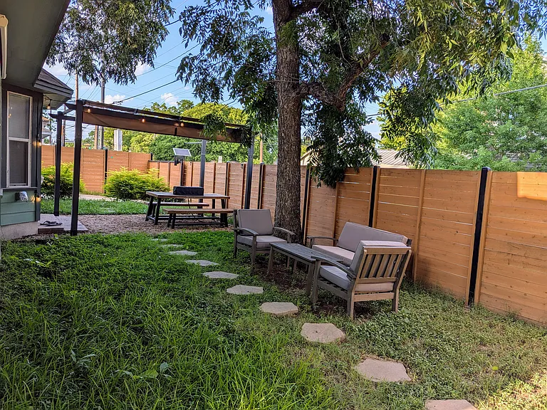 Stepping stones leading to outdoor seating and dining areas in the side yard