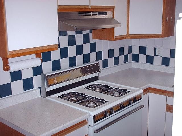 Gas range and oven, overhead fan and light. Two lazy susan pots and pans cabinets.