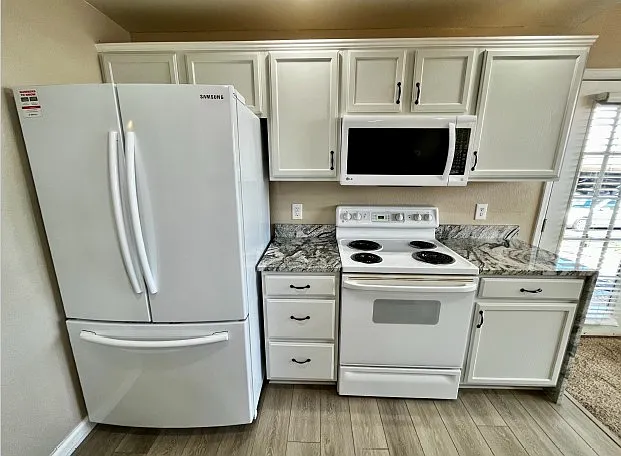 Kitchen includes microwave, oven, and French door refrigerator with pull out freezer.