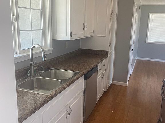 Bright and spacious kitchen with new countertops and freshly painted cabinets and walls with stainless steal stove, sink, and dishwasher