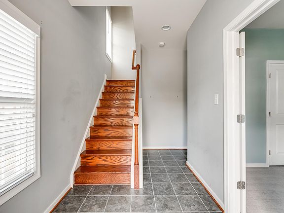 Foyer view from front door. Staircase to second level. Bedroom #1 to the right. Back to the garage.