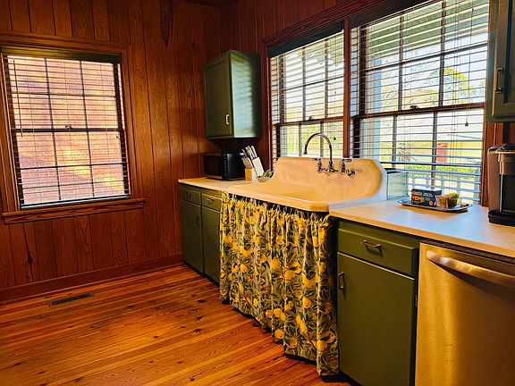 The kitchen has vintage sink and custom wooden walls. New dishwasher, stove, and refrigerator.
