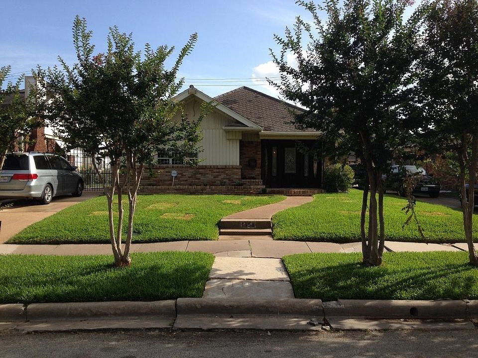 Front of house from street. Notice the beautiful front door, the custom designed flower beds and Wro