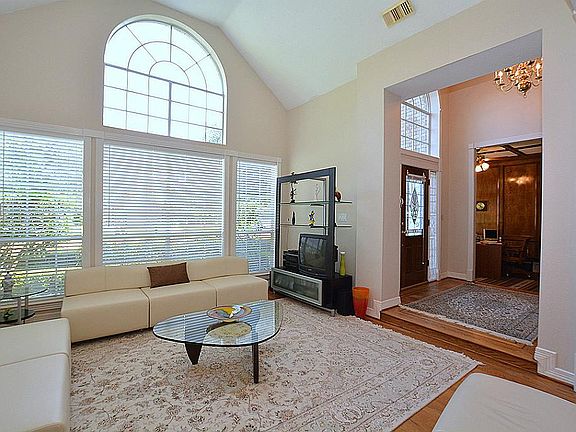 Formal living room off of entry has high ceilings and multiple windows that allow for ample natural 